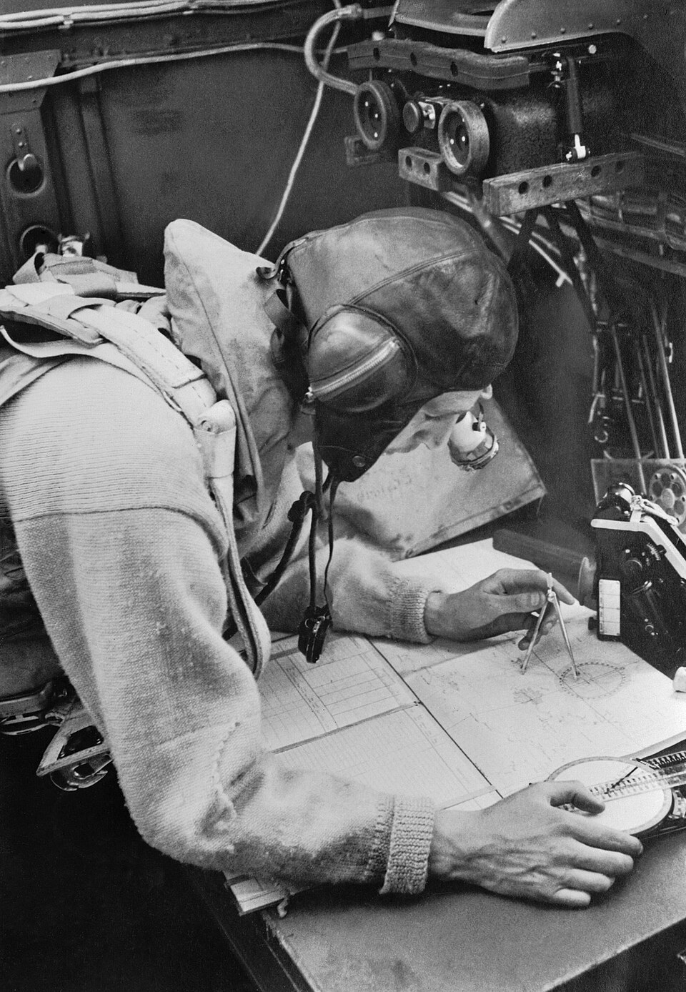 A Cecil Beaton photograph of the navigator working at his chart table in an RAF Stirling bomber, 1941. D4738 2
